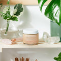 Jar of 'The Organics' cream on a shelf with plants and crystals