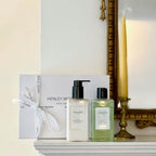 Bathroom products including bottles and a box on a white surface with a decorative mirror in the background.