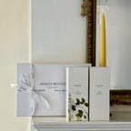 Henley Woods product packaging on a shelf with a candle and decorative mirror.