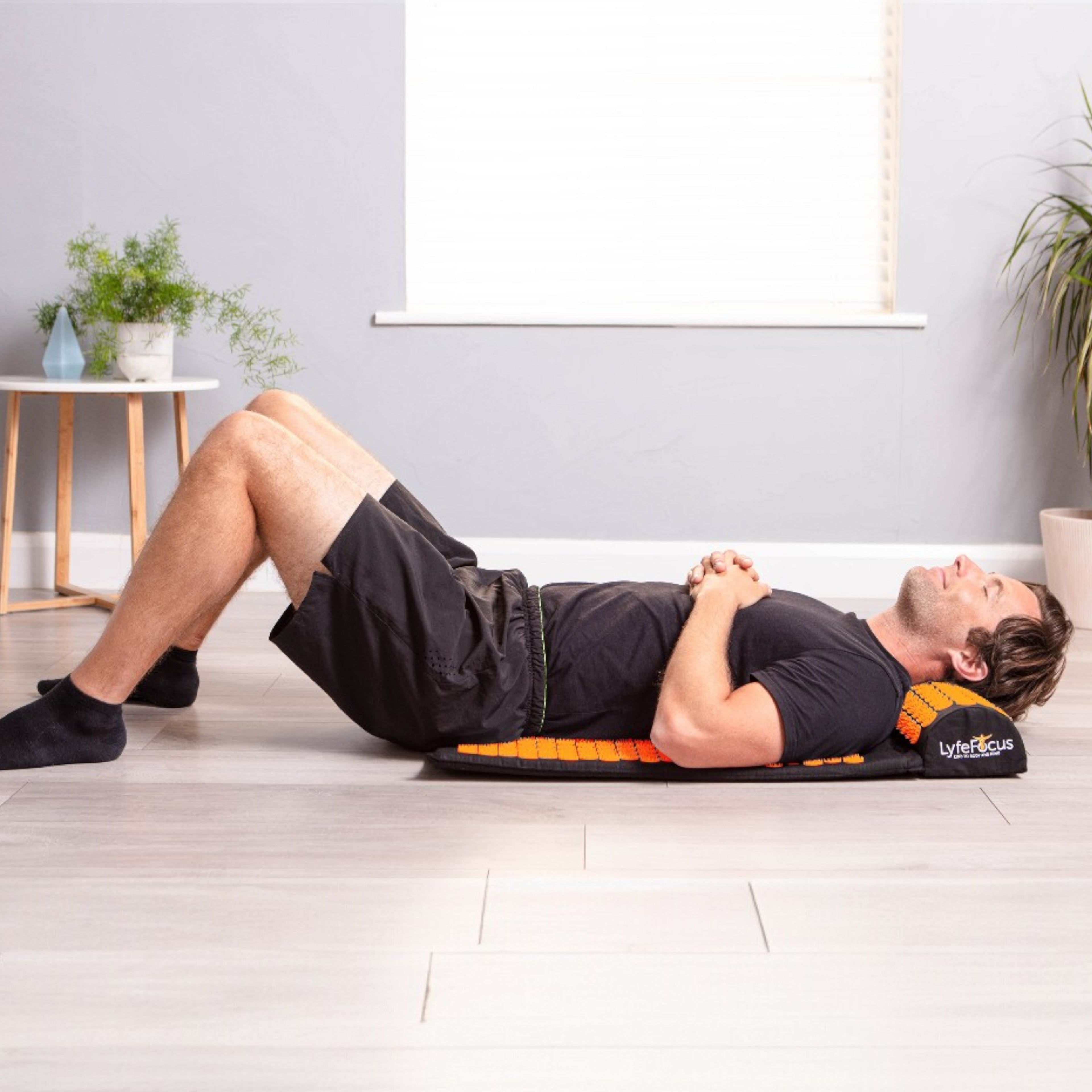 Person using a foam roller on a mat in a home setting