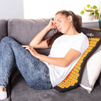 Woman using a back massager on a couch