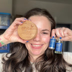 Woman holding a wooden disc and two blue bottles with 'White Mulberry' branding.