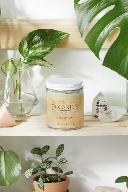 Jar of 'Sufflème Organics' lotion on a shelf with plants and crystals in the background