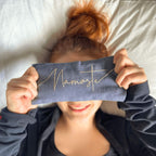 Person wearing a headband with 'Namaste' text, lying on a bed.