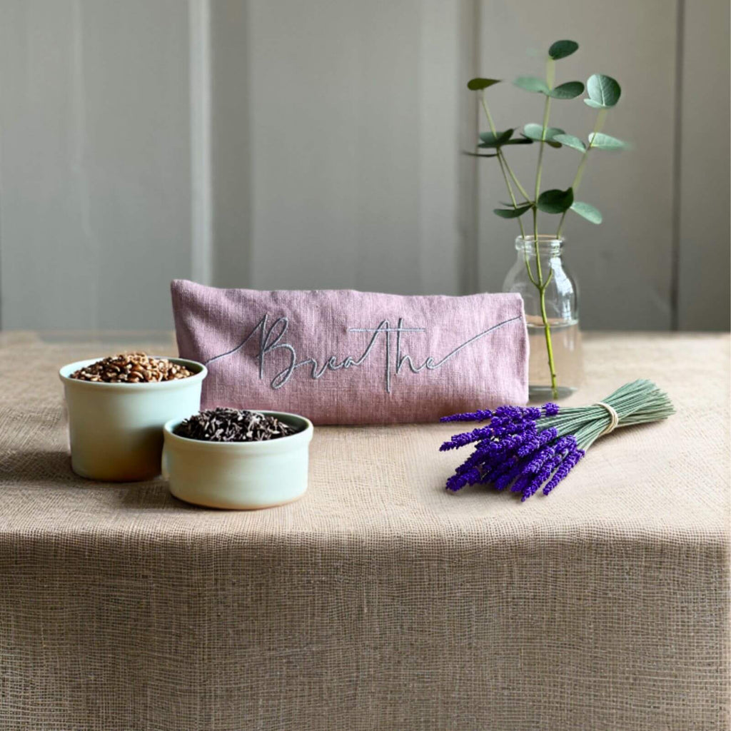 Decorative items on a table including a pink pouch, small plants, and lavender.