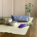 Decorative setting with 'Gratitude' pillow, lavender, and plants on a wooden table.