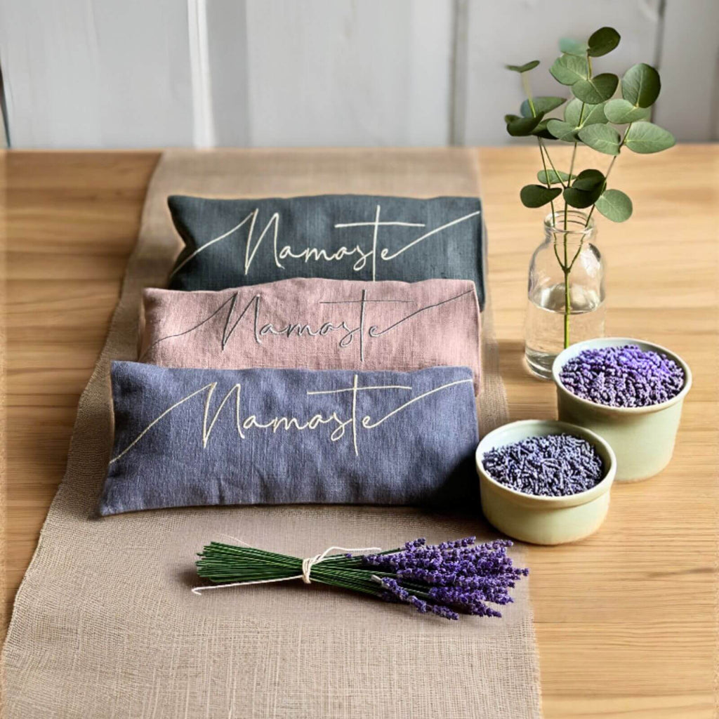 Decorative pillows with 'Namaste' text on a table with lavender and plants.