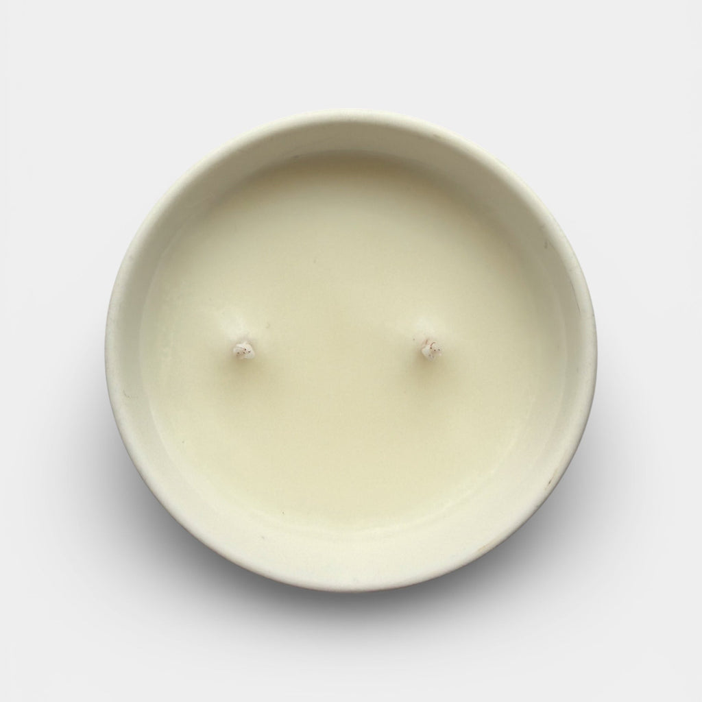 Round beige candle on a light gray background