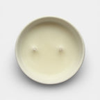 Round beige candle on a light gray background