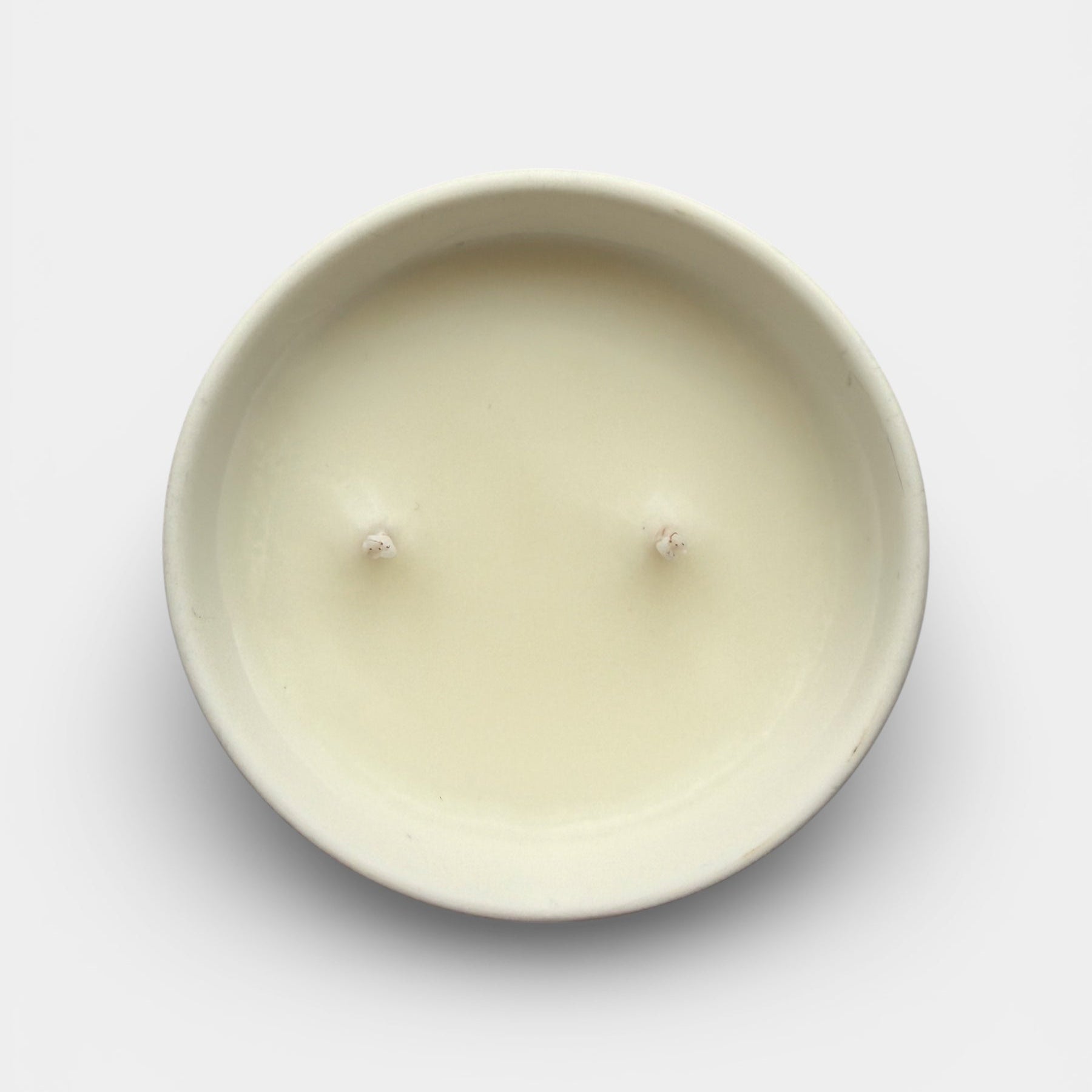 Round beige candle on a light gray background