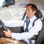 Man driving a car wearing a white shirt and tie.