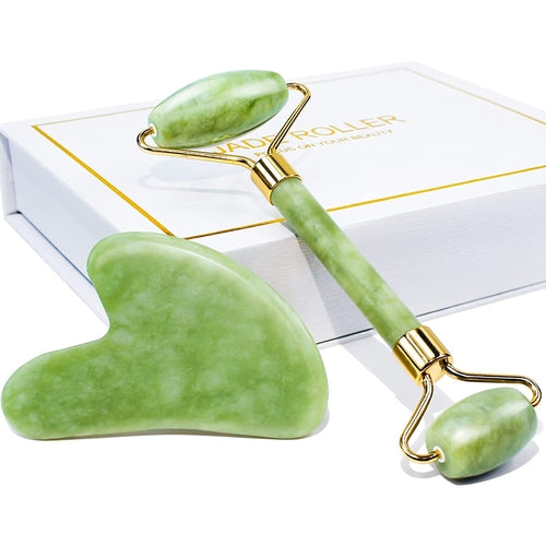 Green jade roller and gua sha tool with gold accents on a white background