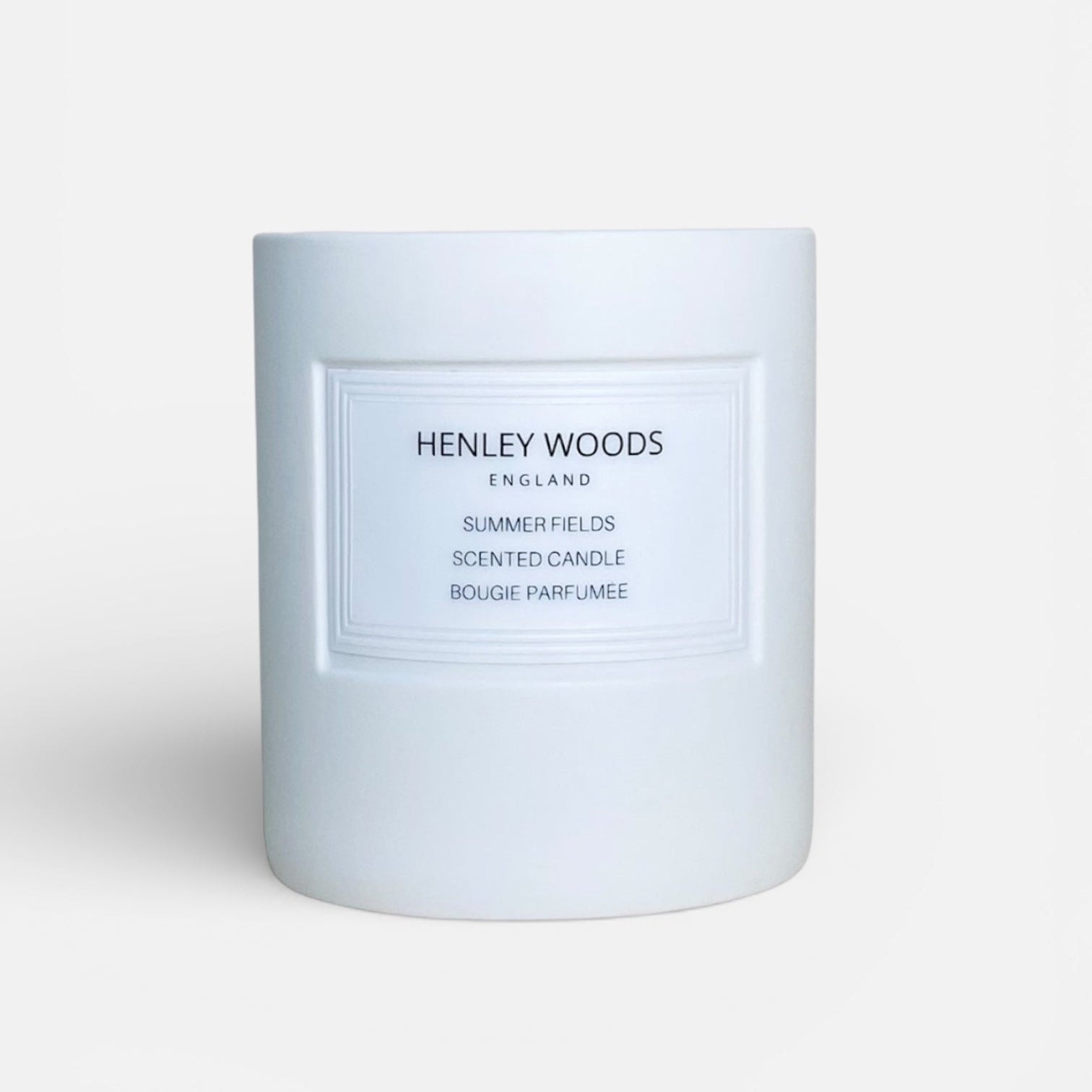 White candle with 'Henley Woods' branding on a light gray background