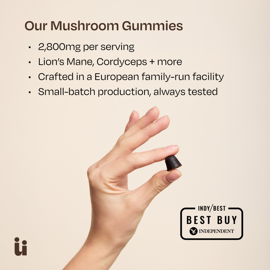 Hand holding a mushroom gummy with product details on a beige background
