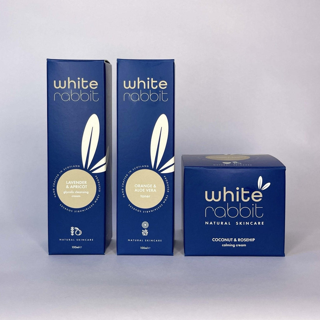 Three blue boxes of White Rabbit skincare products on a white background